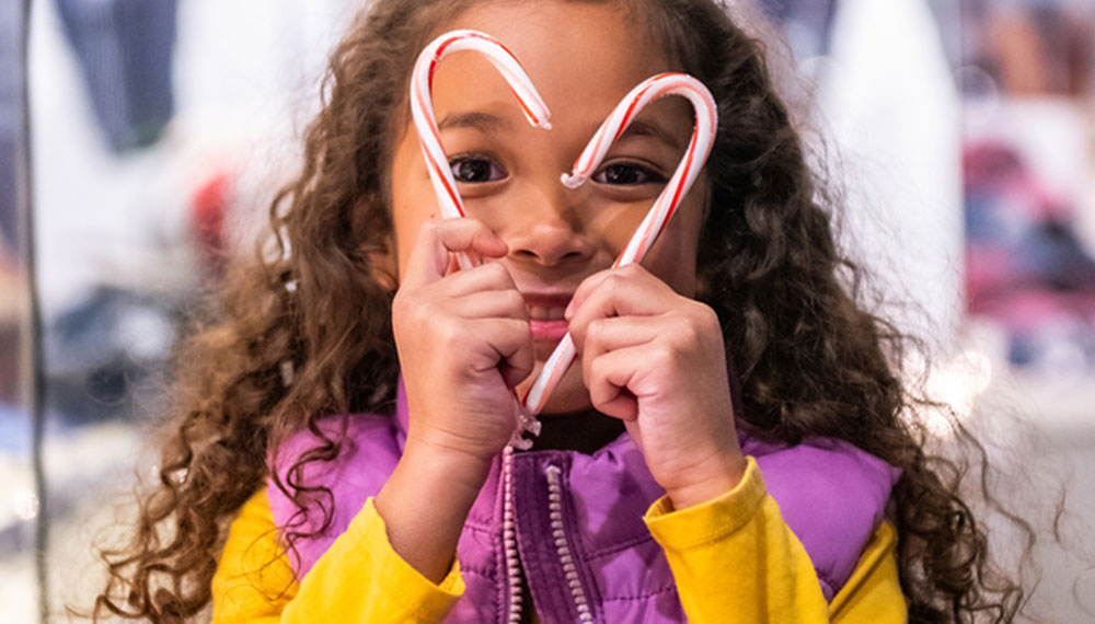 girl holding candy canes